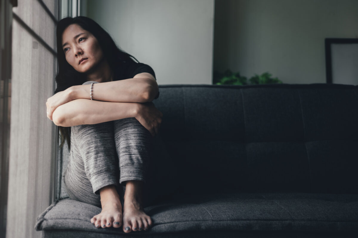 Woman sitting on couch looking contemplative