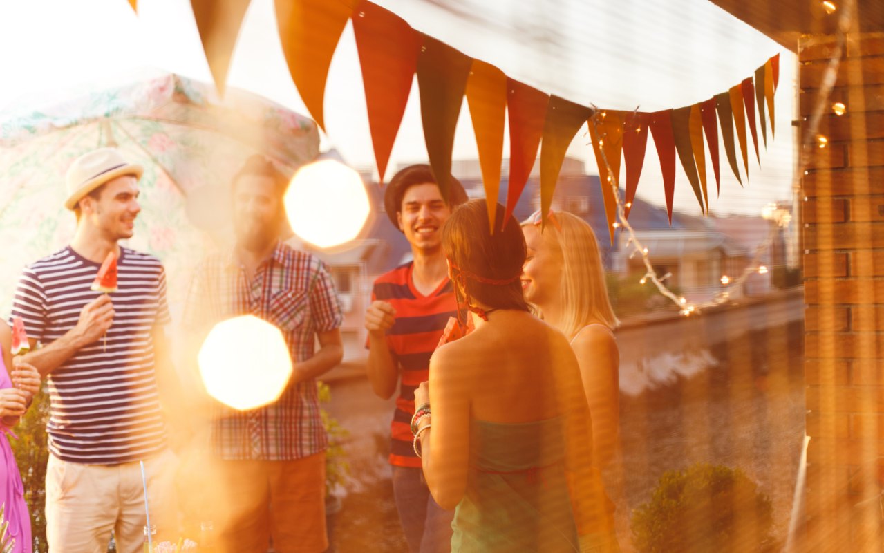 young adults gathering and talking at a party on a summer evening